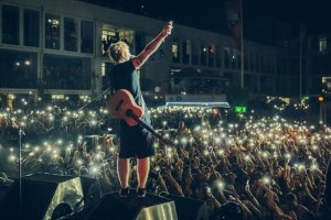 Singing a song and playing guitar in front of a big crowd!